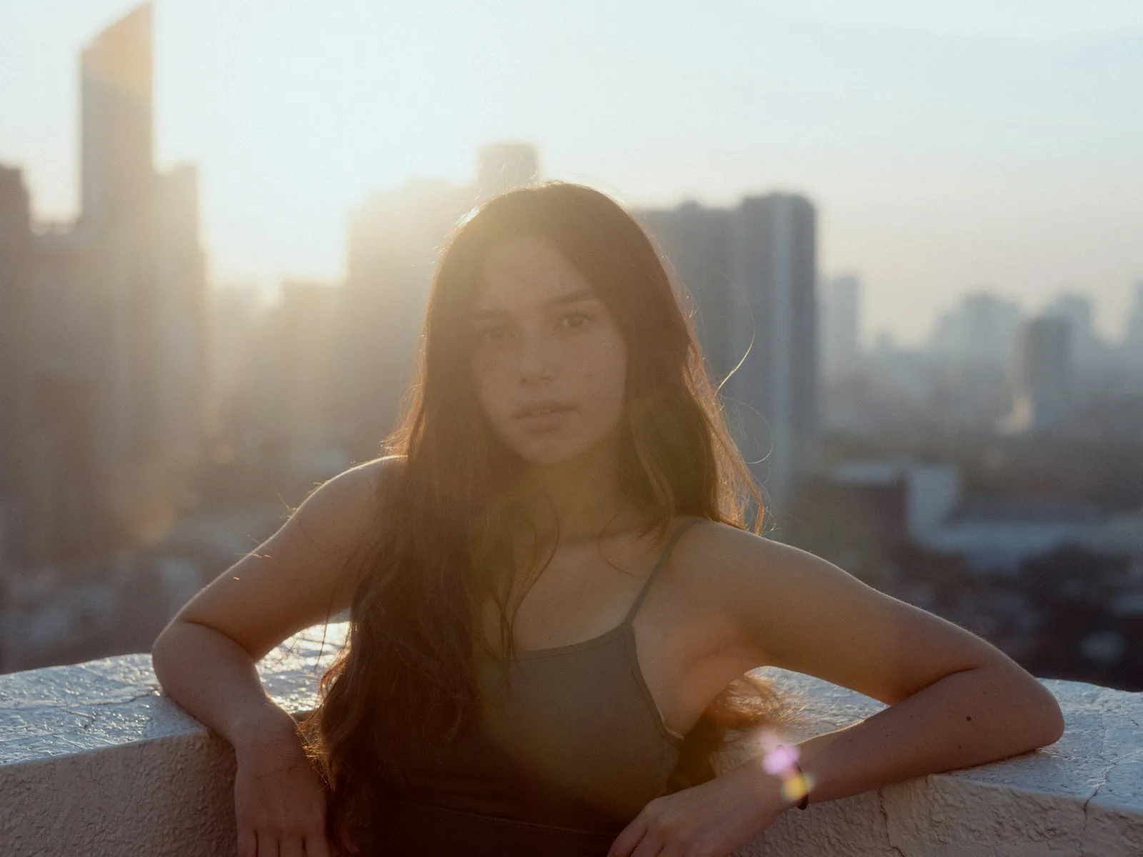 Backlit by the setting sun, the city below