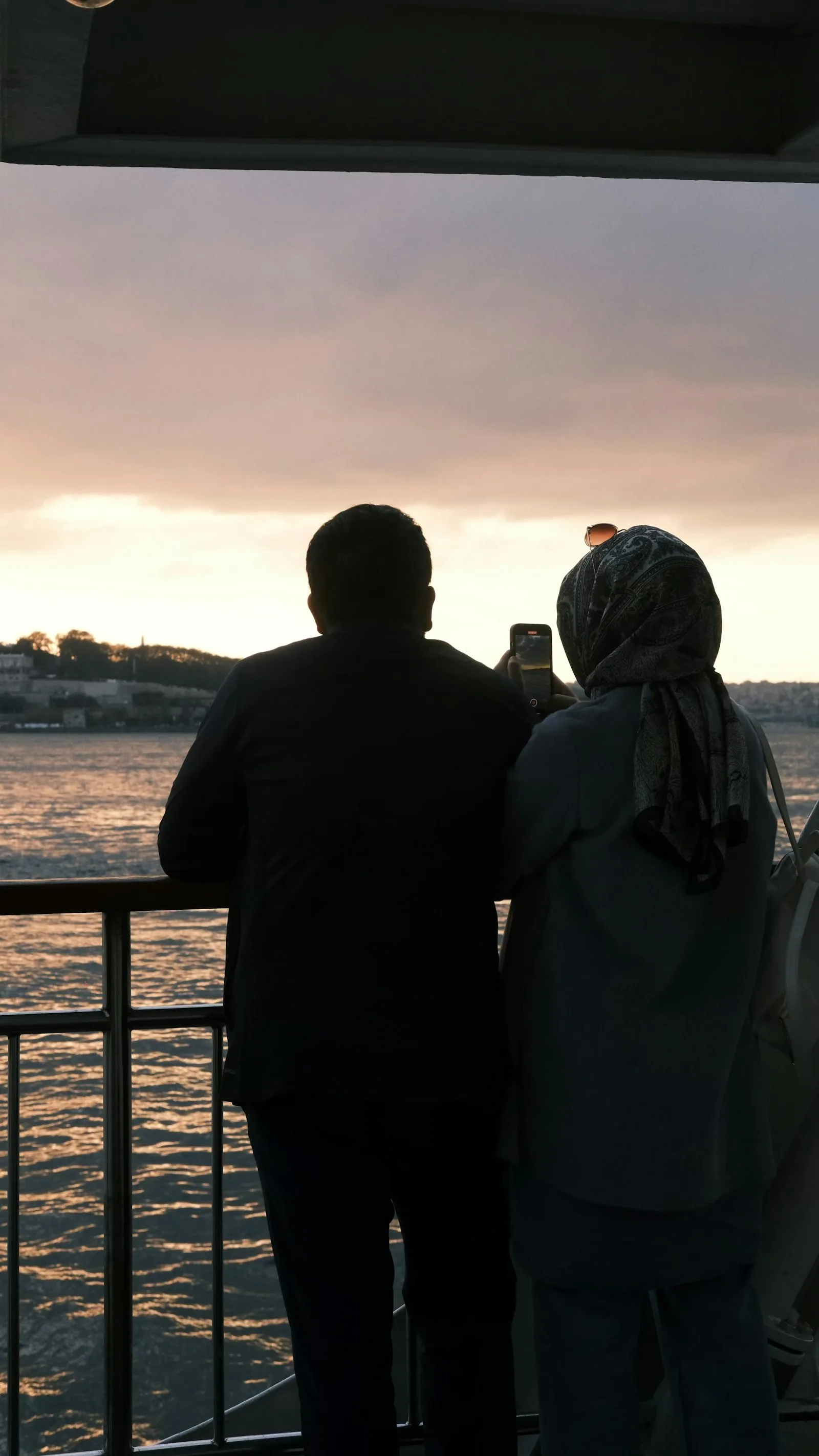 A couple watching the sun go down over the water